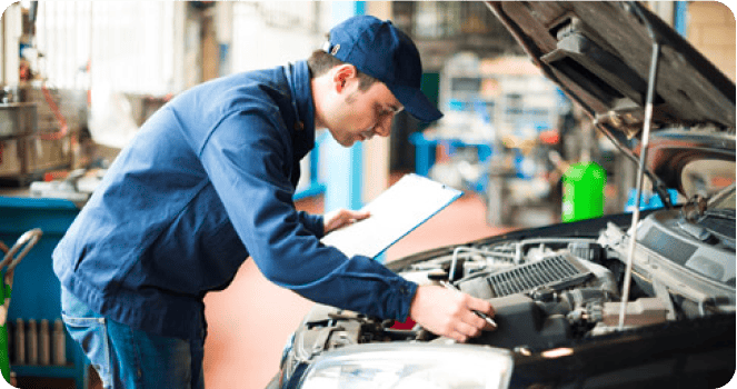 expertise-du-vehicule Épaviste en uniforme attachant soigneusement une voiture sur une dépanneuse, prêt pour un enlèvement respectueux de l'environnement.
